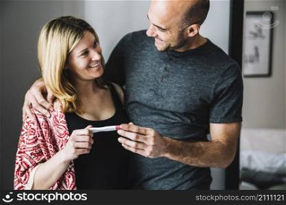 happy woman husband looking pregnancy test