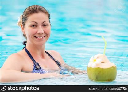 happy woman in a striped bikini and coconut with a straw
