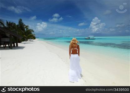happy woman in a white dress on the ocean coast