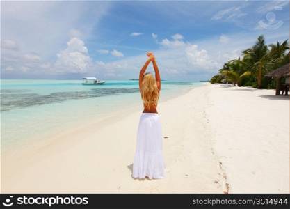 happy woman in a white dress on the ocean coast