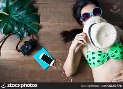 Happy woman in bikini lying down on wooden background, Beauty an. Happy woman in bikini lying down on wooden background, Beauty and Travel concept, Top view
