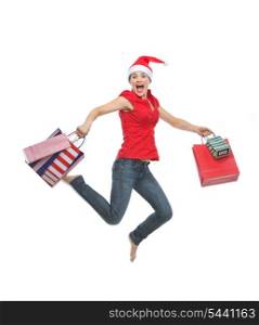 Happy woman in Christmas hat with shopping bags jumping