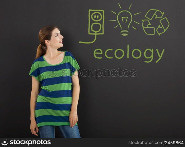 Happy woman in front of a chalkboard with ecology concepts written on it