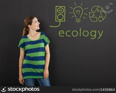 Happy woman in front of a chalkboard with ecology concepts written on it