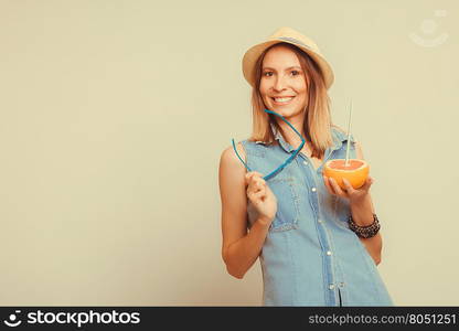 Happy woman in hat holds sunglasses and grapefruit. Happy glad woman tourist in straw hat holding sunglasses and grapefruit citrus fruit. Healthy diet food. Summer vacation holidays concept. Instagram filtered.