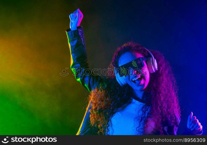 Happy woman in headphones dancing in neon light, smoke background. Z generation enigmatic beautiful lady in leather jacket, eyewear. High quality photo. Happy woman in headphones dancing in neon light, smoke background. Z generation