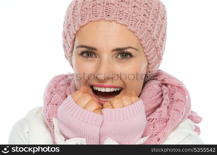 Happy woman in knit scarf, hat and mittens breathing on hands