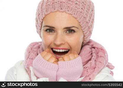 Happy woman in knit scarf, hat and mittens breathing on hands