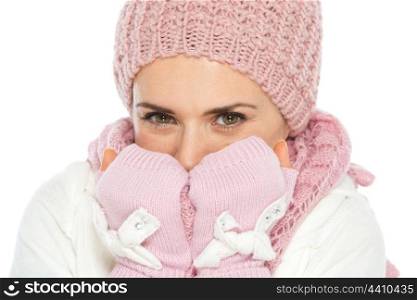 Happy woman in knit winter clothes breathing on hands