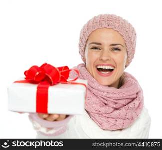 Happy woman in knit winter clothing giving Christmas present box