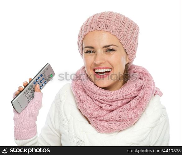 Happy woman in knit winter clothing holding TV remote control