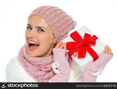 Happy woman in knit winter clothing shaking Christmas present box