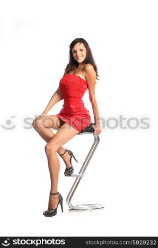 Happy woman in red dress sitting on chair with smile on her pretty face
