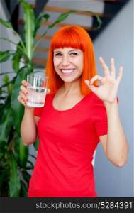 Happy woman in red drinking water and saying Ok