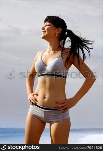 happy woman in sport wear on sea shore