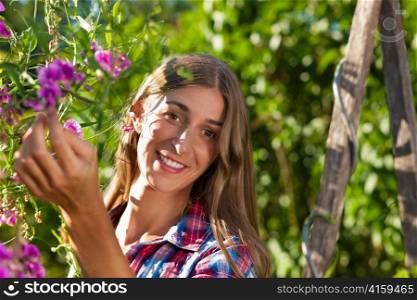 Happy woman in summer in garden with flowers on a wonderful day