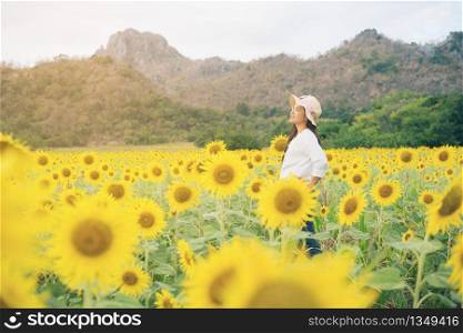 Happy woman in sunflower field smiling with happiness due to healthy food. Happy people, health care and agriculture business concept. Happy farmer or farm worker in sunny day at sunflower field.