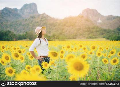 Happy woman in sunflower field smiling with happiness due to healthy food. Happy people, health care and agriculture business concept. Happy farmer or farm worker in sunny day at sunflower field.