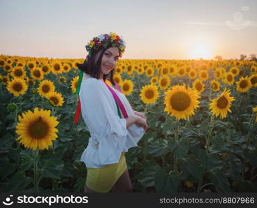 Happy woman in sunflower field. Summer girl in flower field cheerful and joyful.Caucasian young lady in cowboy hat dancing, smiling elated and serene with arms raised up.. Ukrainian girl in flower field cheerful and joyful