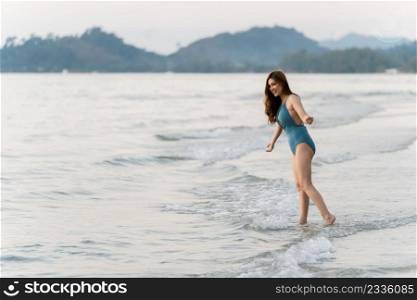 happy woman in swimsuit on the sea beach at Koh Chang island, Thailand