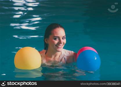 Happy woman in water having fun with balloons. Happy woman in swimming pool water having fun with balloons. Seductive young girl wearing wet white shirt relaxing.