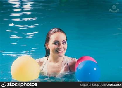 Happy woman in water having fun with balloons. Happy woman in swimming pool water having fun with balloons. Seductive young girl wearing wet white shirt relaxing.