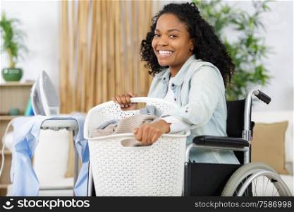 happy woman in wheelchair doing the laundry