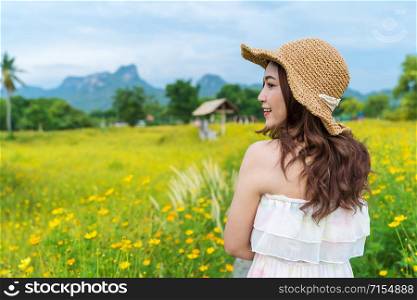 happy woman in yellow cosmos flower field
