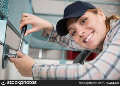 happy woman installing blinds with screwdriver