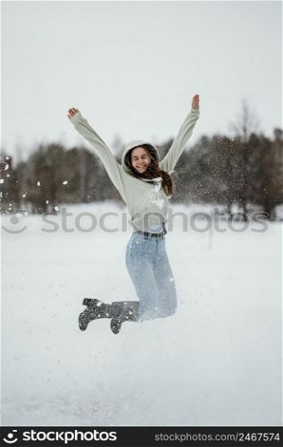 happy woman jumping outdoors winter