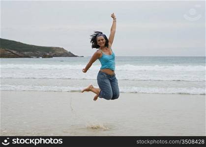Happy woman jumping with a beautiful sea background