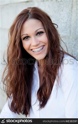 Happy woman laughing with a gray wall background