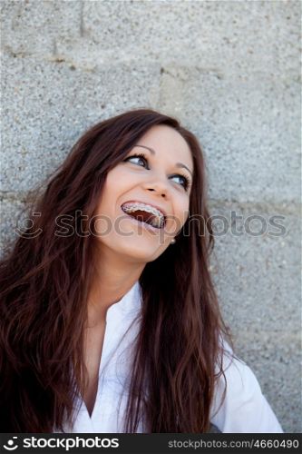 Happy woman laughing with a gray wall background