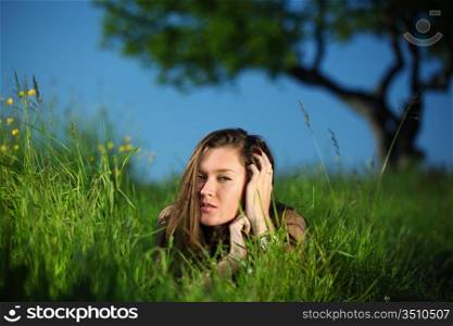 happy woman lay on green grass under tree