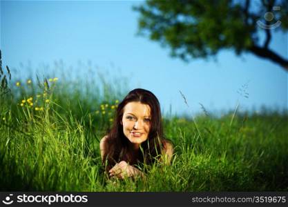 happy woman lay on green grass under tree