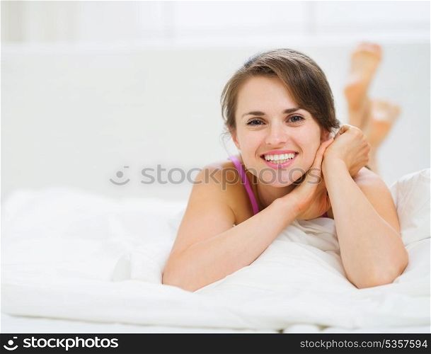 Happy woman laying in bed