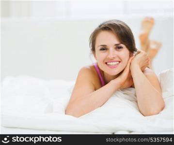 Happy woman laying in bed