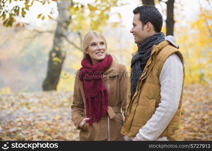 Happy woman looking at man during autumn