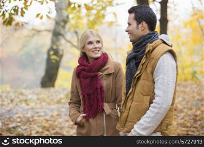 Happy woman looking at man during autumn