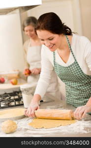 Happy woman making dough for apple pie grandmother peeling apples