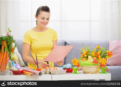 Happy woman making Easter decoration