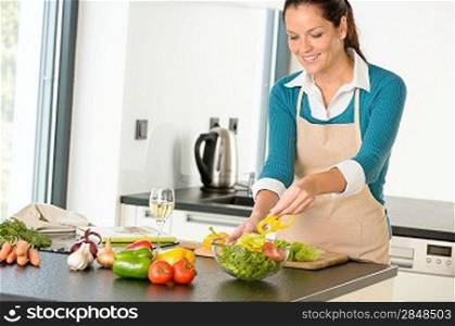 Happy woman making salad kitchen vegetables cooking food