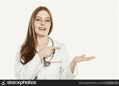 Happy woman medical doctor with stethoscope wearing white coat holding empty palm hand for copyspace. Professional health care advertisement.. Happy woman doctor with empty hand palm copyspace.
