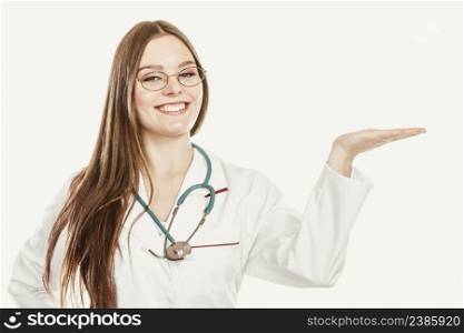 Happy woman medical doctor with stethoscope wearing white coat holding empty palm hand for copyspace. Professional health care advertisement.. Happy woman doctor with empty hand palm copyspace.