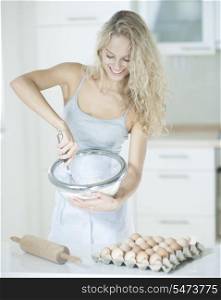 Happy woman mixing cookie batter in kitchen at counter