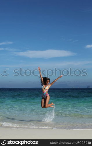 Happy woman on beach. Beautiful happy woman in bikni jump on tropical beach