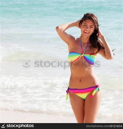Happy woman on beach. Beautiful happy woman in bikni on tropical beach