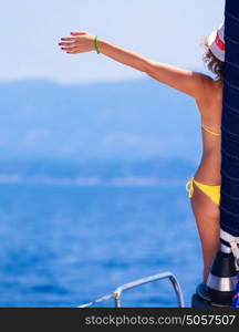 Happy woman on sailboat, back side of cheerful girl with raised up hand enjoying majestic seaview, summer vacation concept