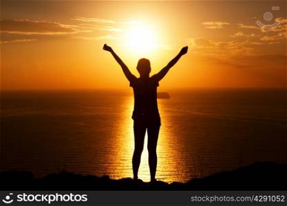 Happy woman on the rock with hands up. Winner, success, active, travel concepts.