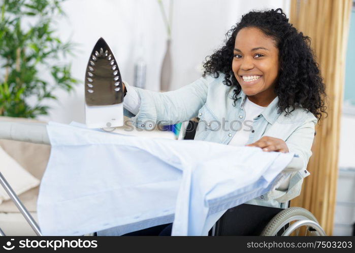 happy woman or housewife with ironing board at home